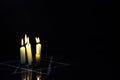 Five burning candles and the Star of David against a black background. Royalty Free Stock Photo