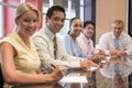 Five businesspeople in boardroom smiling