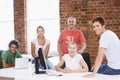 Five businesspeople in office space smiling