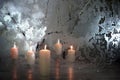 Five candles with warm light and frozen glass with dramatic illumination as a winter decoration for winter holidays in Christmas