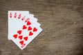 Five card of red heart royal straight flush on wood background