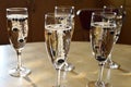 Five champagne sparkling wine glasses filled with champagne and frozen bilberries making visually appealing bubbles