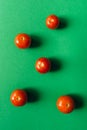 Five cherry tomatoes on a green background. Royalty Free Stock Photo