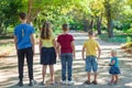 Five children stand in a row on the road in the middle of the tr