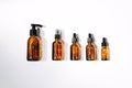 Clear amber bottles with natural cosmetics on a white background. Top view