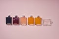 five color bottles, yellow, blue, orange, beige, red, plus one empty sideways, minimalist surroundings Royalty Free Stock Photo