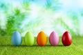 Five colored Easter eggs on short cut grass and abstract background Royalty Free Stock Photo