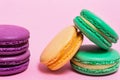 Five colored macaroons on a pink background