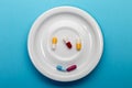 Five colorful medical capsules on a plate Royalty Free Stock Photo