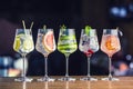 Five colorful gin tonic cocktails in wine glasses on bar counter Royalty Free Stock Photo