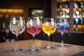 Five colorful gin tonic cocktails in wine glasses on bar counter in pup or restaurant Royalty Free Stock Photo