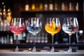 Five colorful gin tonic cocktails in wine glasses on bar counter in pup or restaurant