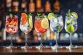 Five colorful gin tonic cocktails in wine glasses on bar counter in pup or restaurant. Royalty Free Stock Photo