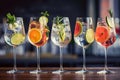 Five colorful gin tonic cocktails in wine glasses on bar counter in pup or restaurant. Royalty Free Stock Photo