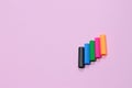 Five colorful pen cap on a pink millennial background. Space to insert the text. Office stuff. Minimalism.