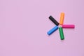 Five colorful pen cap on a pink millennial background. Space to insert the text. Office stuff. Minimalism.