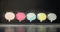Five colorful speech bubbles adorned with glitter on dark surface Royalty Free Stock Photo