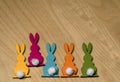 Five colorful wooden Easter bunnies in a row on a wooden underground Royalty Free Stock Photo