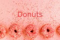 Five coral donuts. Donuts with icing on pink background