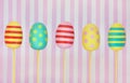 Five decorated colourful Easter eggs on a pink striped background Royalty Free Stock Photo