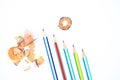 Five different color wood pencil crayons pointing at a wood pencil shavings