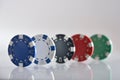 Five different colored gambling game chips on white table Royalty Free Stock Photo