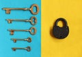 five different golden keys on blue felt and close padlock on yel