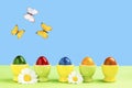 Five eggcups with colorful easter eggs