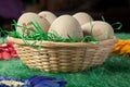 Five eggs in a basket on green fake grass