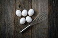 Five Eggs and Whisk or Egg Beater on Rustic Wood Royalty Free Stock Photo