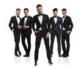 Five elegant grooms in tuxedoes with relaxed leader in front