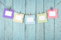 Five empty photo frames hanging with clothespins