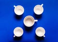 Five empty white coffee cups on a blue background. Top view Royalty Free Stock Photo
