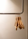Five empty wooden cloth hangers without shirts or dress hanging on a steel rail in the wardrobe on white background.