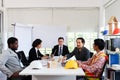 Five engineer business people discussing while sitting at meeting table in office together, multi-ethnic colleagues team working Royalty Free Stock Photo