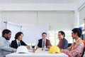 Five engineer business people discussing while sitting at meeting table in office together, multi-ethnic colleagues team working Royalty Free Stock Photo