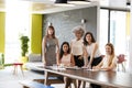 Five female colleagues at a work meeting smiling to camera