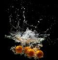 Fresh oranges falling in water