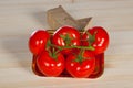 Five fresh red tomatoes with green stem in the tray , isolated on the background Royalty Free Stock Photo