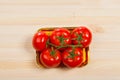 Five fresh red tomatoes with green stem in the tray , isolated on the background Royalty Free Stock Photo