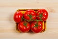 Five fresh red tomatoes with green stem in the tray , isolated on the background Royalty Free Stock Photo