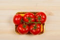 Five fresh red tomatoes with green stem in the tray , isolated on the background Royalty Free Stock Photo