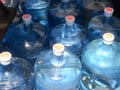 Five 5 gallon water bottles full and empty blue plastic dry and condensation Royalty Free Stock Photo