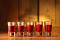 Five glasses with cranberry vodka