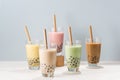 Five glasses of healthy milky boba or bubble tea flavored with fresh fruit and chocolate and served with traditional wide straws Royalty Free Stock Photo