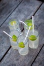 Five glasses of lemonade on a rough wooden table. Cocktails with gin, tonic and lime on a rough wooden background. Royalty Free Stock Photo