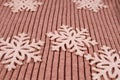 Five glitter snowflakes on a flat knitted beige cashmere fabric