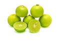 Five green limes in pyramid stacking and two splitted halves on white background. Royalty Free Stock Photo