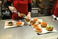 Inside a Five Guys hamburger kitchen with people serving fries and burgers, London