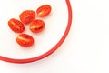 Five half tomatoes on white plate Royalty Free Stock Photo